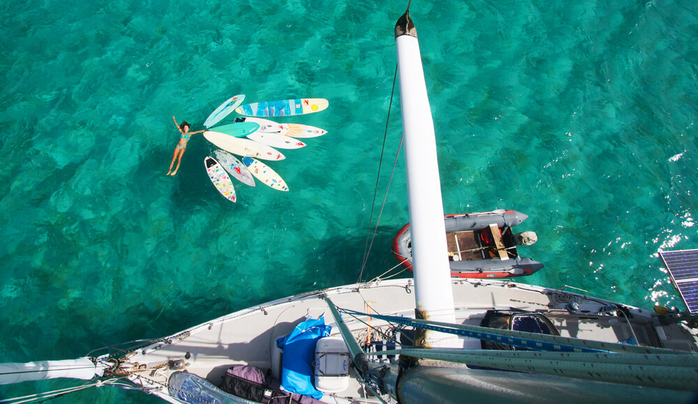 Liz Clark floating in water with surfboards