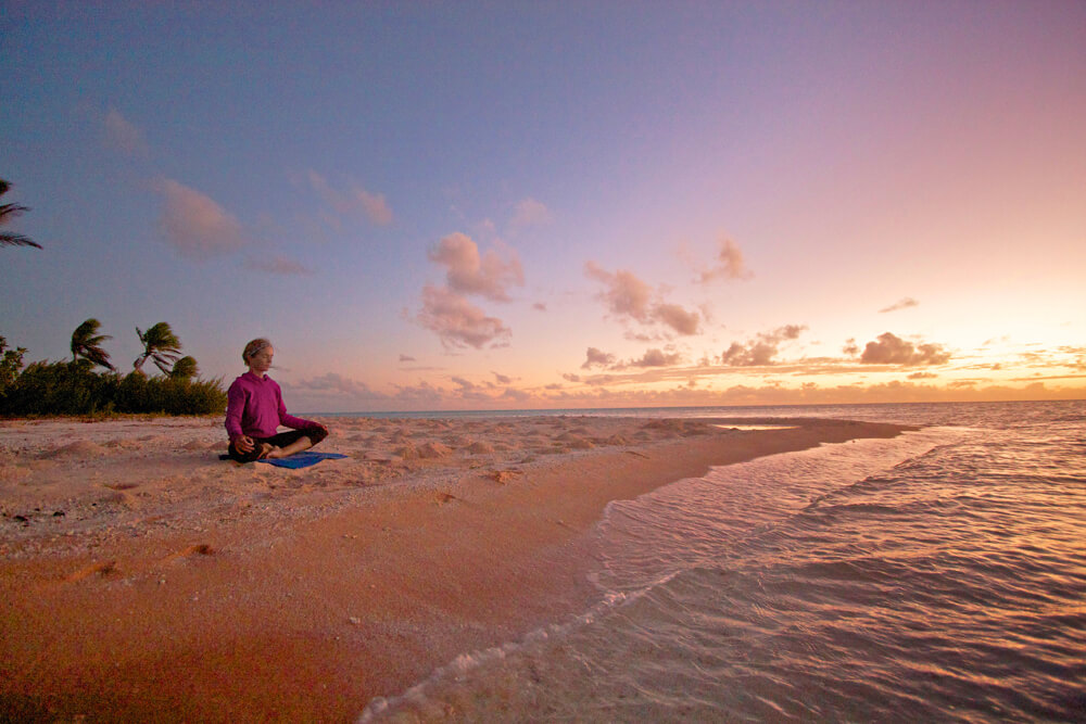 Liz Clark doing yoga on the beach